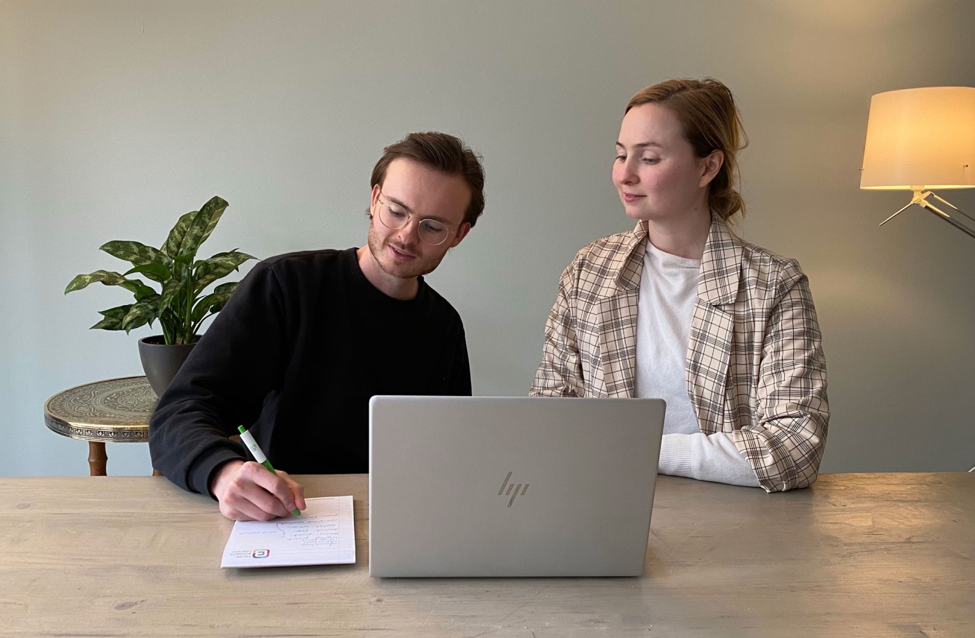 Koen and Titia behind a laptop, having a meeting about the website